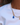 A close-up of a person wearing a layered necklace with a silver chain, gold paperclip links, a blue bear charm, and a small gold key charm, styled over a white t-shirt.